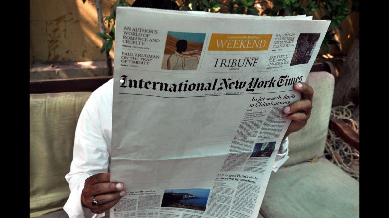 <strong>March 24:</strong> A man reads a copy of the International New York Times at an office in Karachi, Pakistan. The New York Times said <a href="http://www.nytimes.com/2014/03/23/business/media/times-report-on-al-qaeda-is-censored-in-pakistan.html" target="_blank" target="_blank">an article about Pakistan's relationship to al Qaeda was censored</a> by its local distributor in the country, leaving a blank space on its weekend edition.