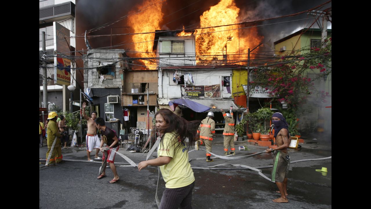 <strong>April 29:</strong> Residents help firefighters put out a blaze that engulfed a neighborhood in Manila, Philippines.