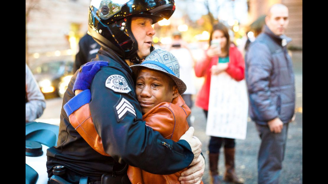 Then-12, Devonte Hart and Sgt. Bret Barnum share a hug at a rally in Portland.