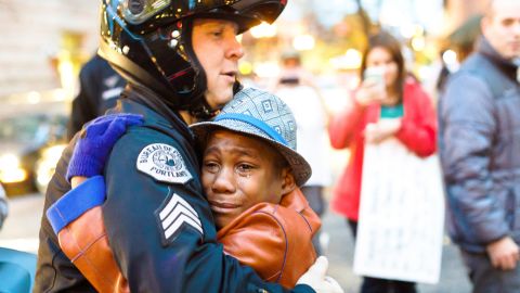 Then-12, Devonte Hart and Sgt. Bret Barnum share a hug at a rally in Portland.