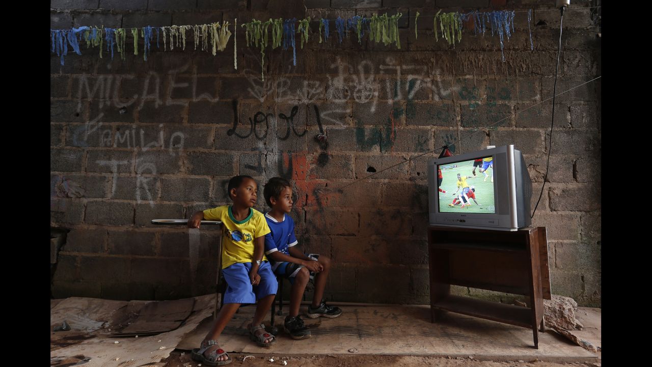 <strong>June 17:</strong> Boys at a slum on the outskirts of Brasilia, Brazil, watch a World Cup soccer match between Brazil and Mexico. Brazil hosted this year's World Cup, although <a href="http://www.cnn.com/2014/06/12/world/gallery/world-cup-protests/index.html">there were protests</a> over whether the money spent on the tournament would have been better used elsewhere.