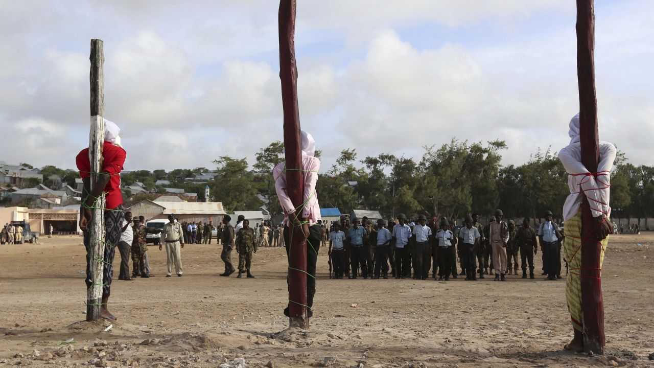 <strong>August 3:</strong> Three men found guilty by a Somali military court of killing civilians and masterminding an attack on the presidential palace are tied to poles shortly before they were executed by a firing squad in Mogadishu, Somalia. The three were members of the militant group Al-Shabaab.