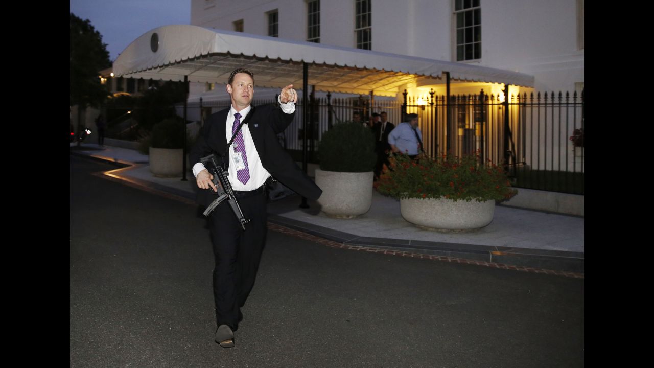 <strong>September 19:</strong> A U.S. Secret Service agent hurries people to evacuate the White House complex moments after a security breach. President Barack Obama and his family were not at home when an intruder scaled the fence and entered the White House, but a congressional inquiry uncovered other security lapses this year and <a href="http://www.cnn.com/2014/10/01/politics/gallery/obama-administration-resignations-firings/index.html">led to the resignation</a> of Secret Service Director Julia Pierson.