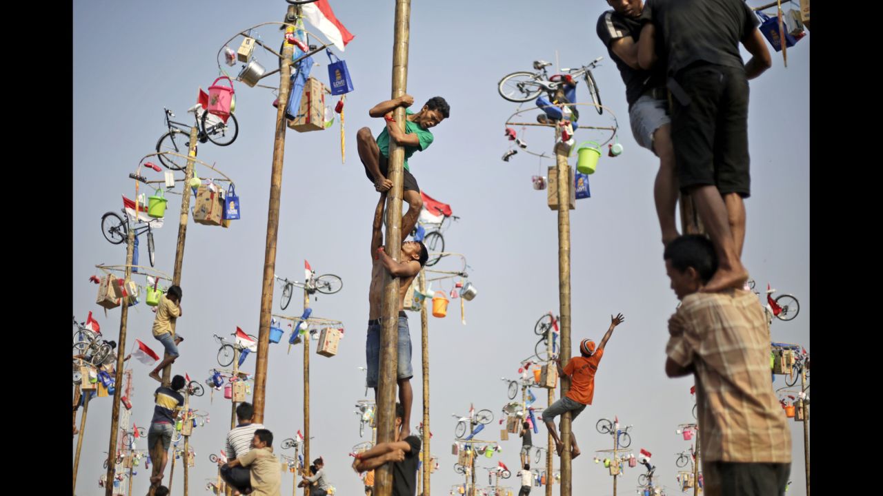 <strong>August 17:</strong> People in Jakarta, Indonesia, struggle to climb greased poles during a competition that was part of the country's Independence Day celebrations.