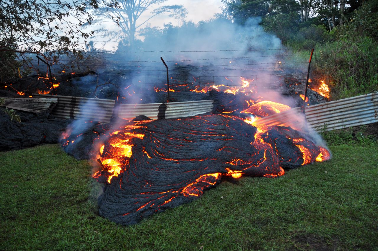 <strong>October 28:</strong> Lava from <a href="http://www.cnn.com/2014/10/28/us/gallery/kilauea-volcano/index.html">the Kilauea volcano</a> pours past a boundary fence in Pahoa, Hawaii. The flow was picking up speed, prompting emergency officials to close part of the main road through town and tell residents to be prepared to evacuate.
