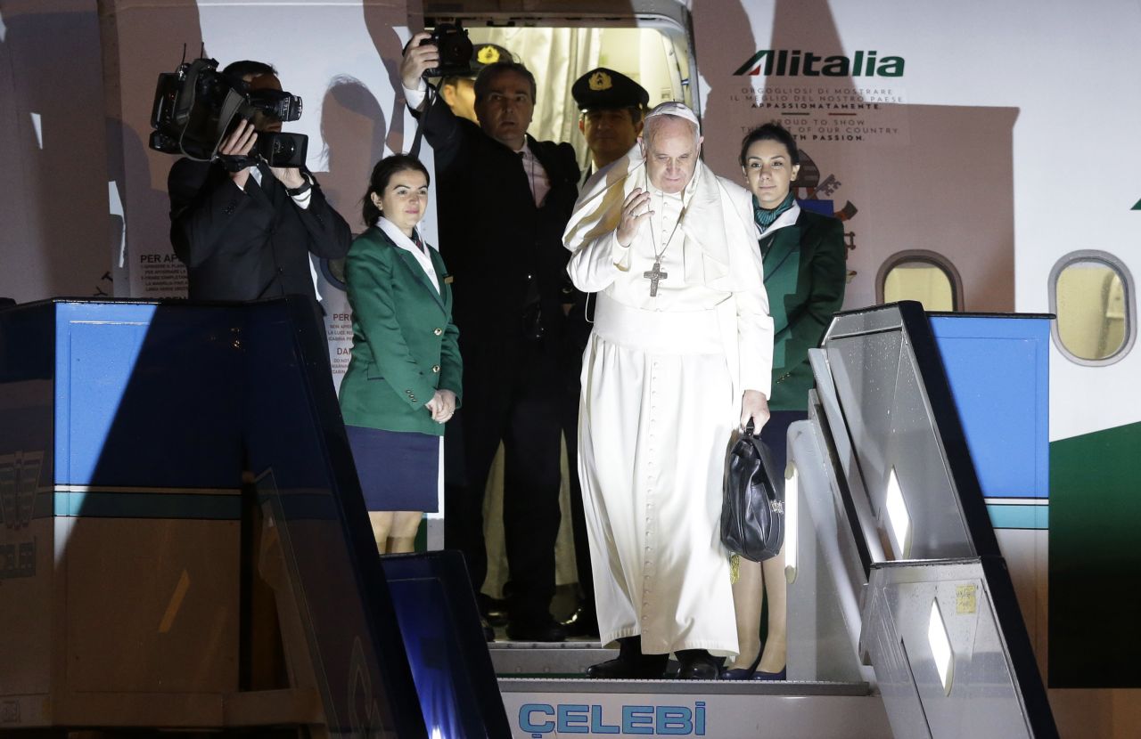 Pope Francis waves as he boards a plane for Rome at the Istanbul Ataturk airport on Sunday, November 30, concluding his three day visit the the predominantly Muslim country. 
