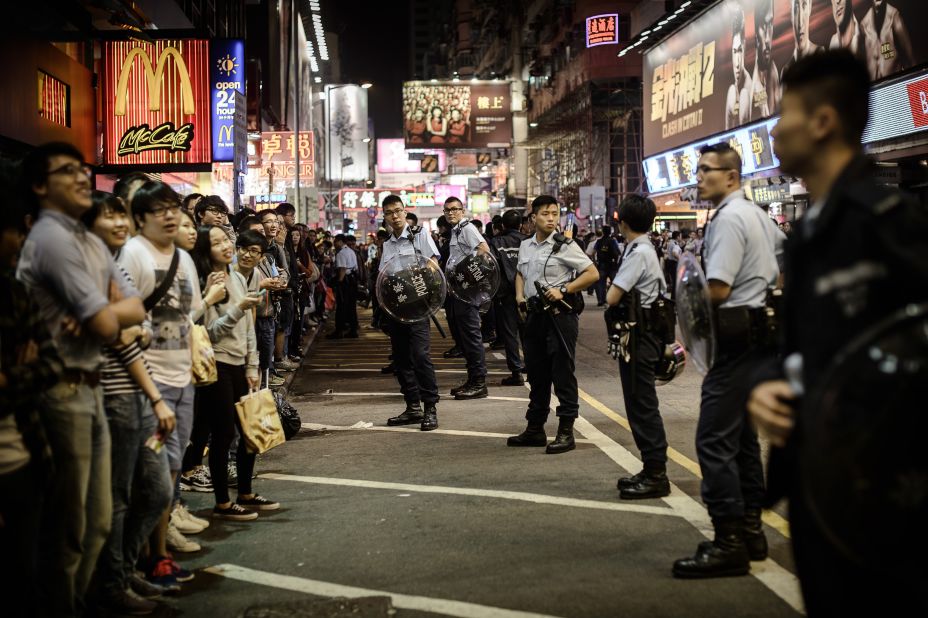 Policemen keep vigil as pro-democracy demonstrators gather on street parallel to where a protest site was cleared in the Mongkok district of Hong Kong on Friday, November 28.