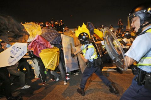 Pro-democracy protesters collide with police officers on the main road outside the government headquarters in Hong Kong on November 30. 