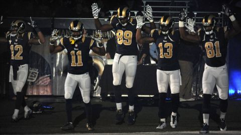 Members of the St. Louis Rams raise their arms as they walk onto the football field in St. Louis before their game against the Oakland Raiders on November 30.