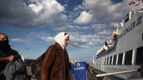 Syrian refugees board a boat bound for Turkey at a port in Kyrenia, Cyprus, on Sunday, November 23. Some 220 Syrian migrants crammed onto a fishing boat were rescued by a cruise ship off Cyprus' northern coast after their vessel hit rough seas in the Mediterranean Sea, authorities said. 