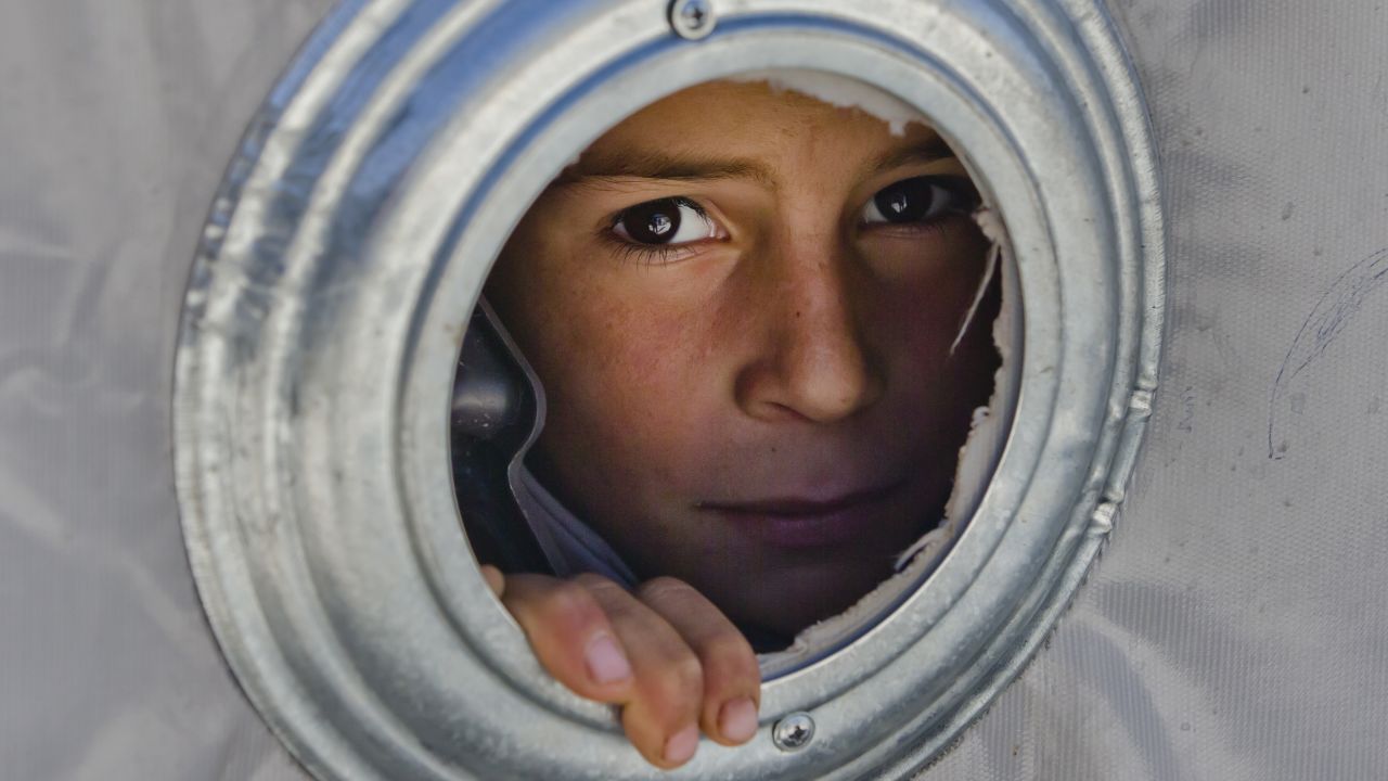 A Syrian Kurdish child looks through the ventilation hole of a tent at a camp in Suruc, Turkey, on  Wednesday, November 19. Tens of thousands of people fled the Syrian city of Kobani, alson known as Ayn al-Arab, because of the militant group ISIS.
