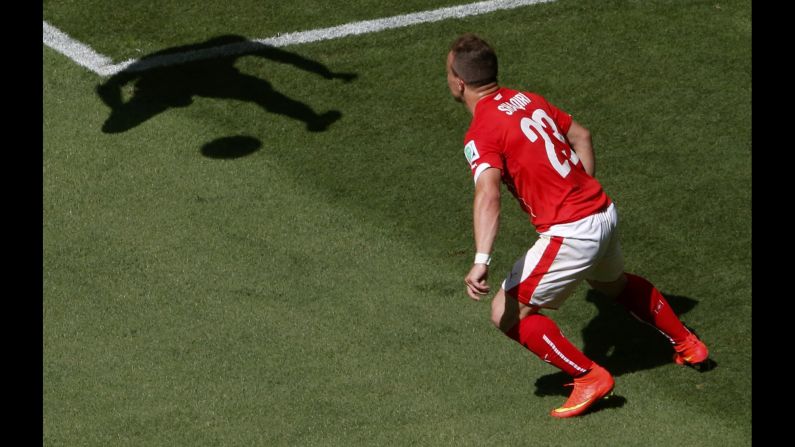 El suizo Xherdan Shaqiri observa la sombra de Walter Ayovi, de Ecuador, durante un partido de la Copa del Mundo el sábado 14 de junio en Brasilia, Brasil.