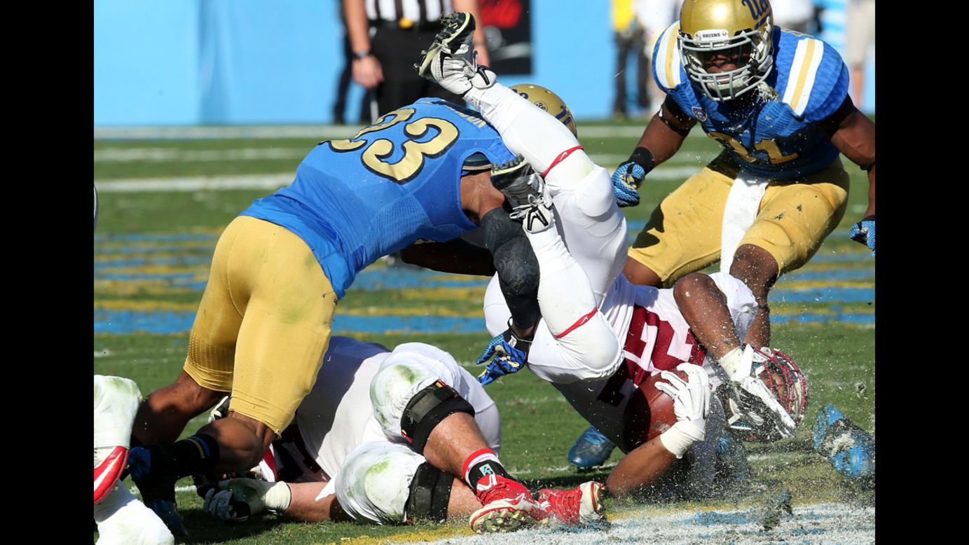 UCLA defensive back Anthony Jefferson upends Stanford running back Remound Wright during a Pac-12 game played Friday, November 28, in Pasadena, California. Stanford won 31-10, ruining UCLA's hopes of a conference title.