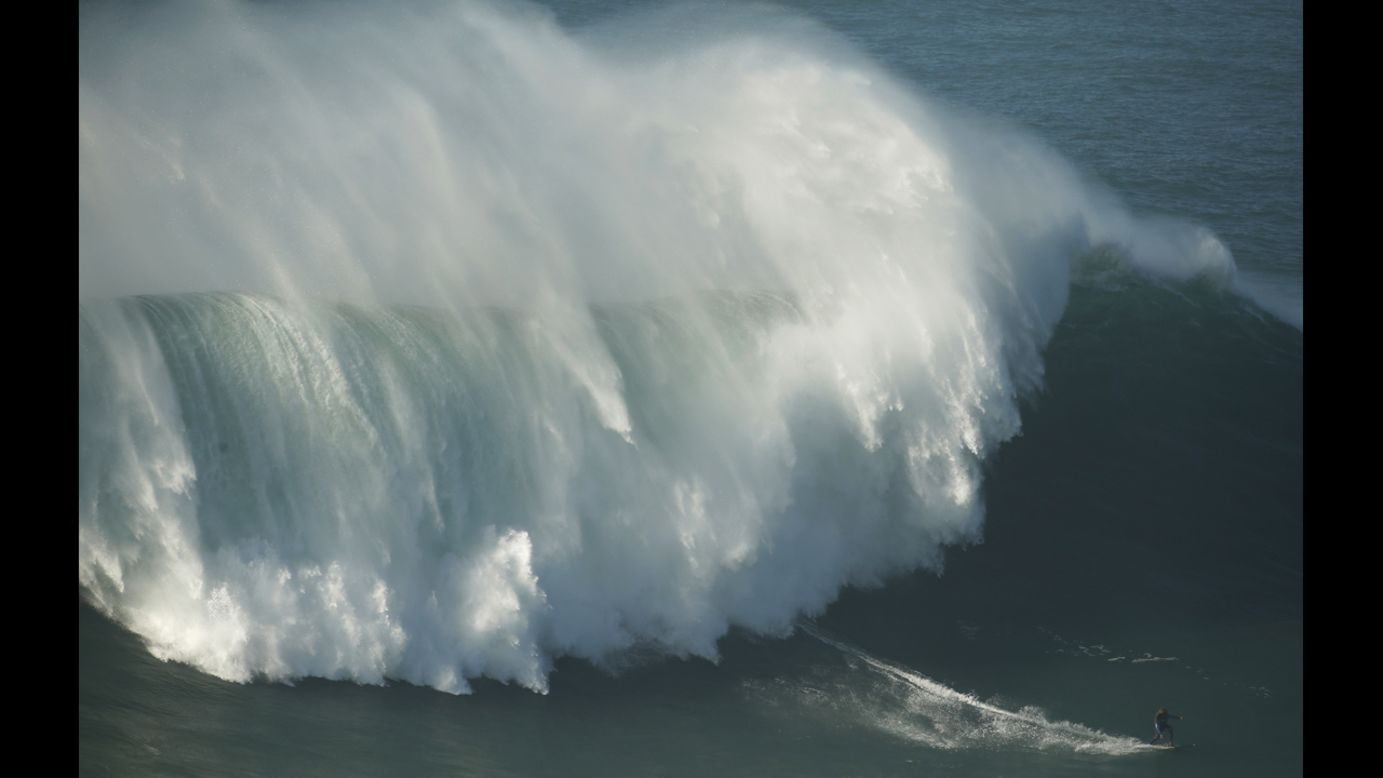 Surfer Kealii Mamala is trailed by a large wave at Praia do Norte, Portugal, on Saturday, November 29.