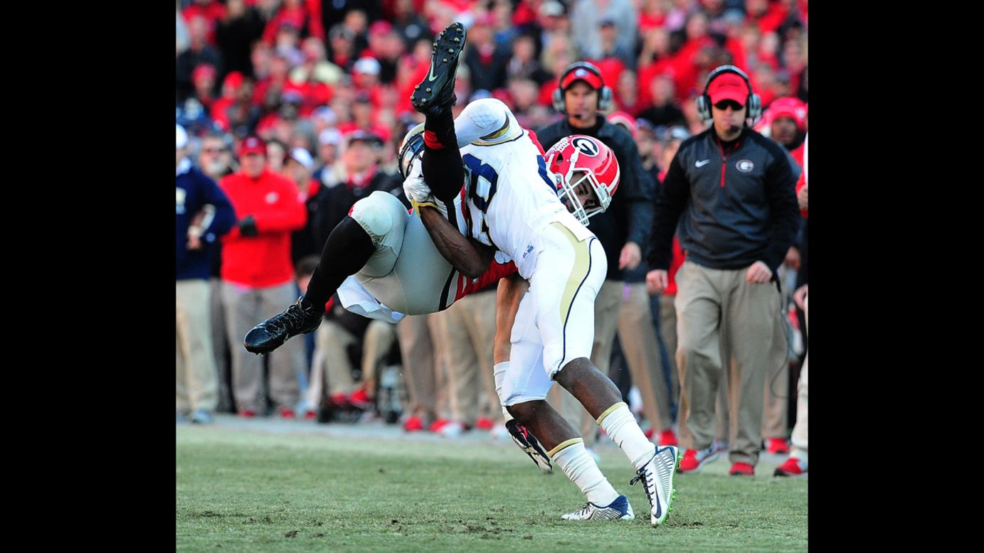 Georgia Tech's D.J. White tackles Georgia's Jeb Blazevich during a college football game Saturday, November 29, in Athens, Georgia. Georgia Tech won 30-24 in overtime, its first win over its rival since 2008.