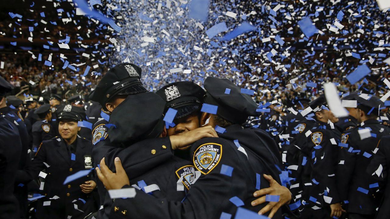 <strong>June 30:</strong> Members of the New York City Police Academy embrace during their graduation ceremony.