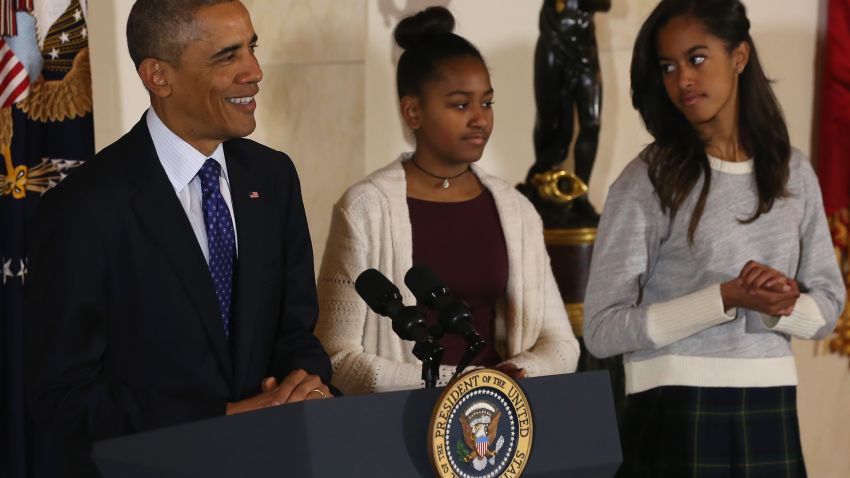 Caption:WASHINGTON, DC - NOVEMBER 26: (L to R) U.S. President Barack Obama speaks as his daughters Sasha and Malia look on before pardoning 'Cheese' and his alternate Mac both, 20-week old 48-pound Turkeys, during a ceremony at the White House November 26, 2014 in Washington, DC. The Presidential pardon of a turkey has been a long time Thanksgiving tradition that dates back to the Harry Truman administration.(Photo by Mark Wilson/Getty Images)