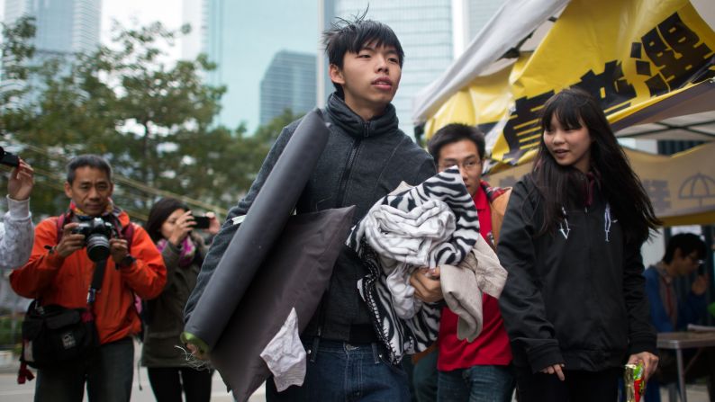 Student protest leader <a href="index.php?page=&url=http%3A%2F%2Fwww.cnn.com%2F2014%2F12%2F01%2Fworld%2Fasia%2Fhong-kong-protest-joshua-wong-hunger-strike%2F">Joshua Wong</a> carries his belongings toward a tent at the main protest site in Hong Kong's Admiralty district on Tuesday, December 2. Wong and two other student demonstrators have begun a hunger strike to demand discussions with Hong Kong's leaders over political reform for the city.