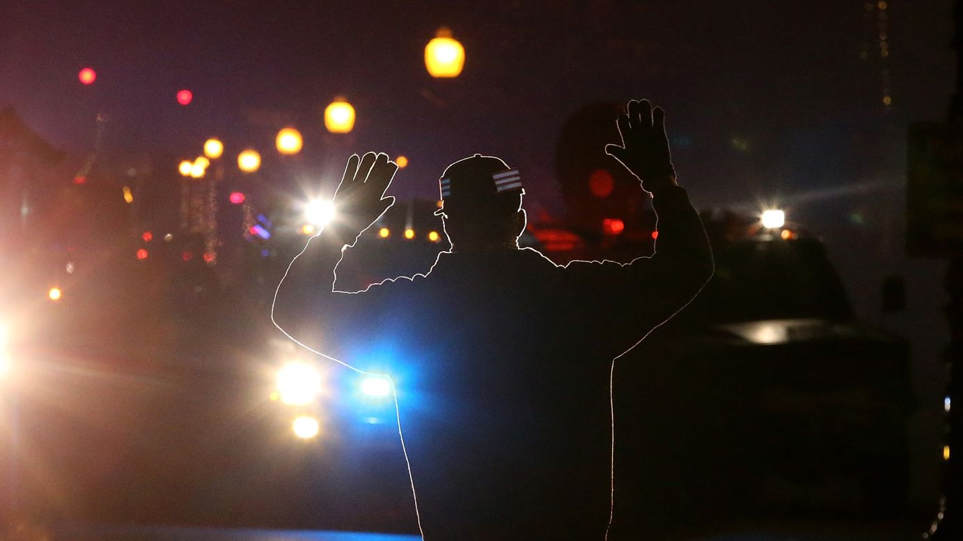 <strong>November 24:</strong> A protester in Ferguson, Missouri, stands in front of police vehicles with his hands up. A grand jury's decision not to indict police officer Darren Wilson for the killing of Michael Brown prompted <a href="http://www.cnn.com/2014/11/24/justice/gallery/ferguson-reaction/index.html">new waves of protests in Ferguson</a> and across the country.