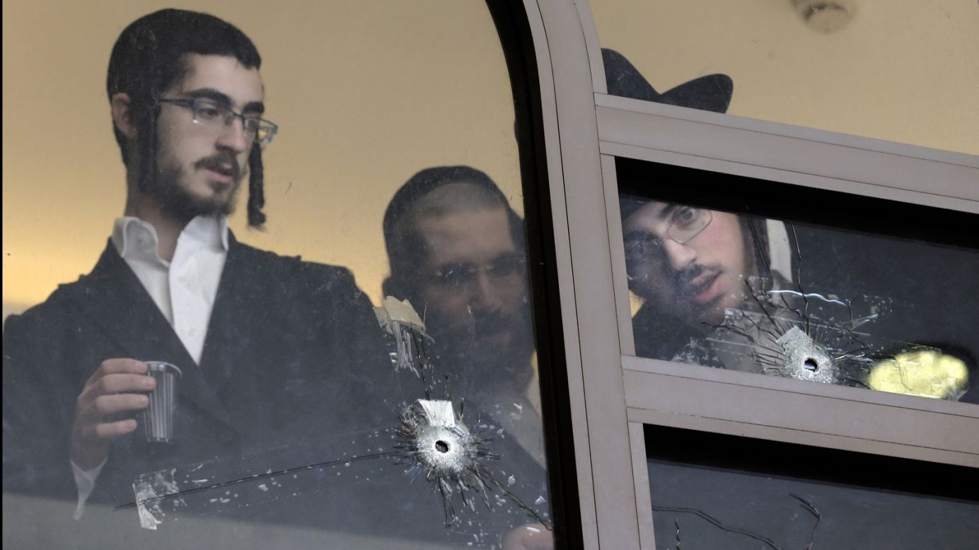 <strong>November 18:</strong> Men look at bullet holes on the main window of a Jerusalem synagogue that was attacked by two Palestinian men. <a href="http://www.cnn.com/2014/11/18/middleeast/gallery/jerusalem-synagogue-attack/index.html">Four worshippers and a police officer were killed and several others were wounded</a> in the deadliest terror attack in Jerusalem since 2008.