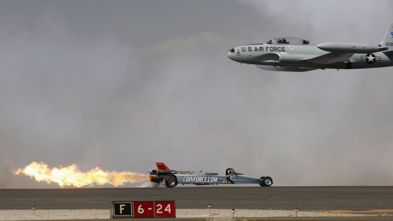 <strong>March 21:</strong> A Lockheed T-33 Shooting Star flies past the Smoke-N-Thunder jet car during a race between the two at the Los Angeles County Air Show.