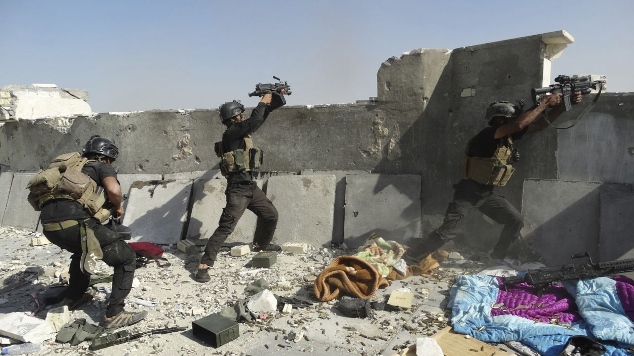 <strong>June 19:</strong> Members of Iraq's Special Operations Forces take their positions during clashes with the ISIS militant group Thursday, June 19, in Ramadi, Iraq. ISIS <a href="http://www.cnn.com/2014/06/13/world/gallery/iraq-under-siege/index.html">has been advancing in Iraq and Syria</a> as it seeks to create an Islamic caliphate in the region.