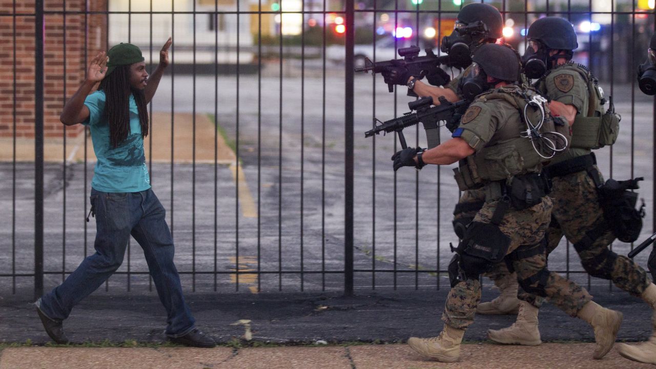 <strong>August 11:</strong> Police wearing riot gear confront a man during <a href="http://www.cnn.com/2014/08/14/us/gallery/ferguson-missouri-protests/index.html">protests in Ferguson, Missouri.</a> Some protests in the city turned into clashes between angry citizens and police after Michael Brown, an unarmed black teenager, was killed by Darren Wilson, a white police officer, on August 9.