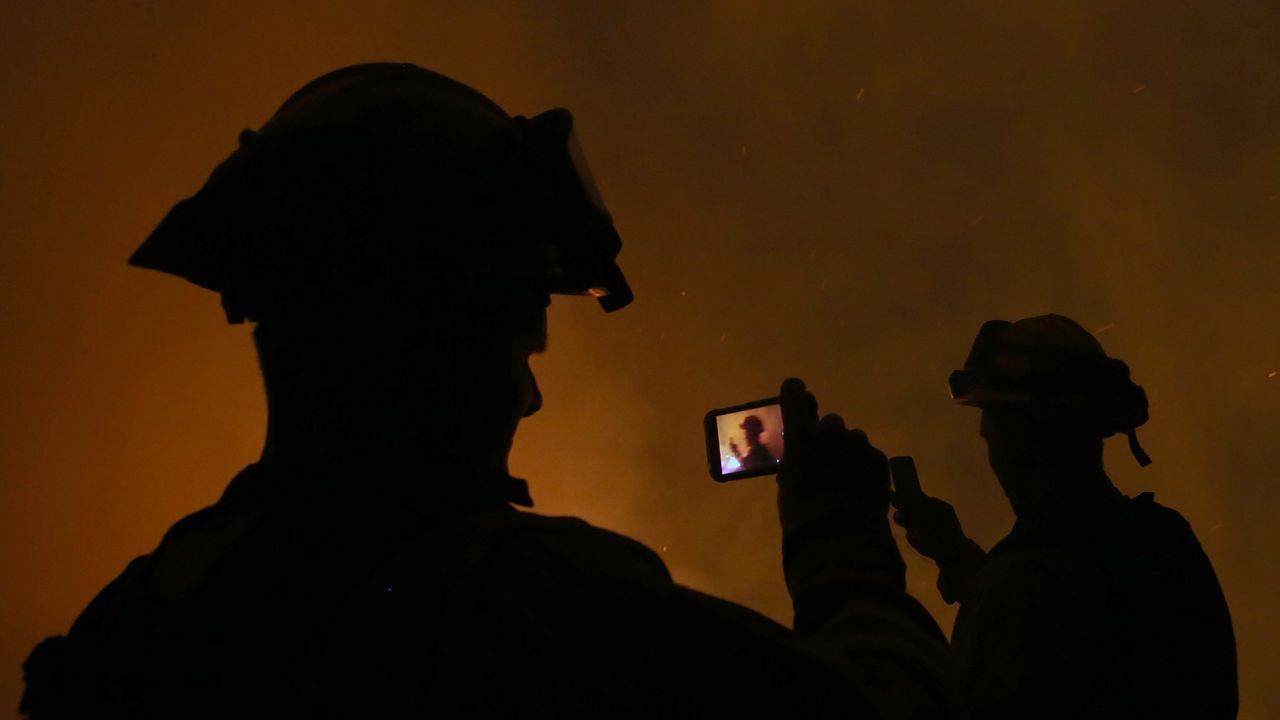 <strong>September 17: </strong>Firefighters take pictures with their cell phones as they monitor a backfire in Fresh Pond, California. California Gov. Jerry Brown declared a state of emergency where <a href="http://www.cnn.com/2014/09/18/us/gallery/california-oregon-wildfires/index.html">wildfires torched tens of thousands of acres.</a>