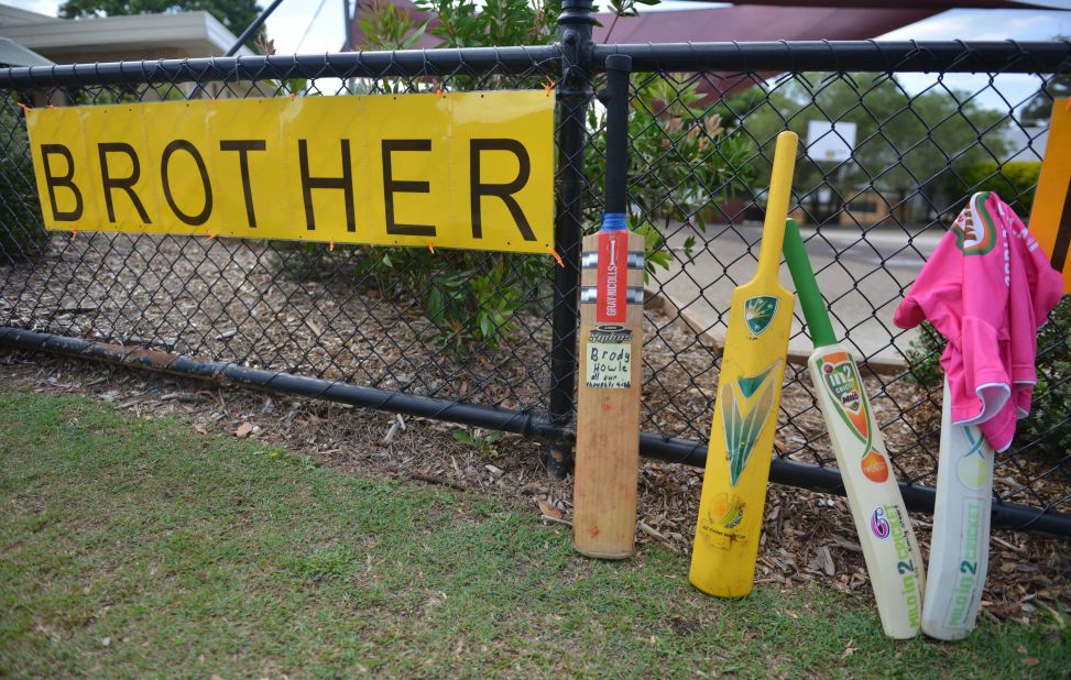 Cricket bats and signs are placed outside St. Patrick's Primary School hours before the funeral of Australian batsman Phil Hughes. 