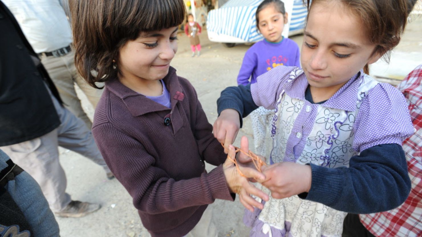Oulah, 5, and Zareh, 7, play cat's cradle with a piece of found twine. The children rely on their imaginations alone for play. While children claim their greatest needs are toys, parents say the priority now must be in preparing for the harsh change in seasons.
