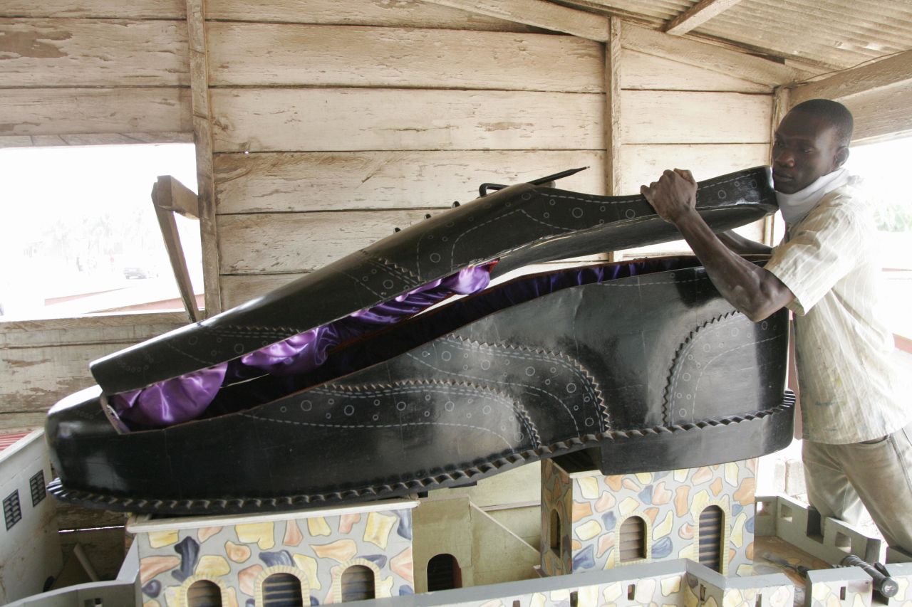 A Ghanaian undertaker opens a coffin, shaped like a shoe, in his showroom in Accra in 2008. 