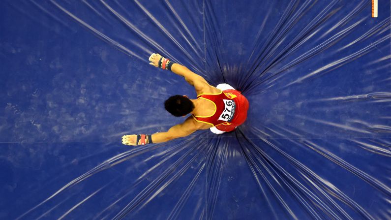 El gimnasta chino Lin Chaopan cae luego de hacer su rutina en la barra horizontal el martes 7 de octubre en el Campeonato Mundial de Gimnasia en Nanning, China. Él y los gimnastas chinos se llevaron el oro en el concurso completo por equipos.