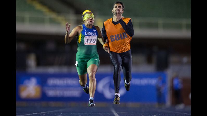 La velocista Terezinha Guilhermina compite en los 200 metros junto a su guía, Guilherme Santana, durante la final de T11 de los Campeonatos Abiertos Brasileños de Atletismo, el jueves 24 de abril. La categoría T11 es para los atletas que tienen una discapacidad visual.