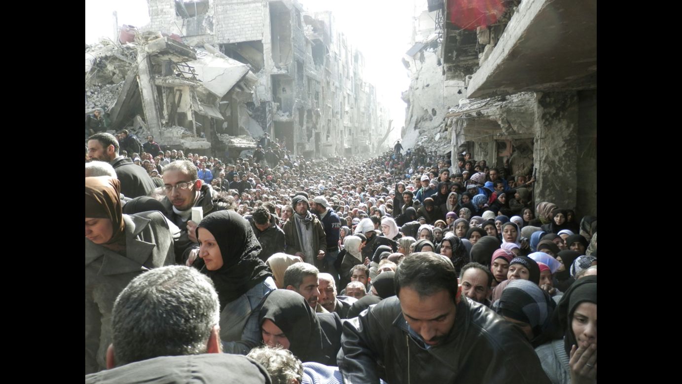<strong>January 31:</strong> Refugees at the besieged al-Yarmouk camp, south of Damascus, Syria, wait to receive food distributed by the U.N. Relief and Works Agency. Millions of people <a href="http://www.cnn.com/2013/03/05/world/gallery/syrian-refugees/index.html">have either fled Syria or become displaced</a> because of the civil war there.