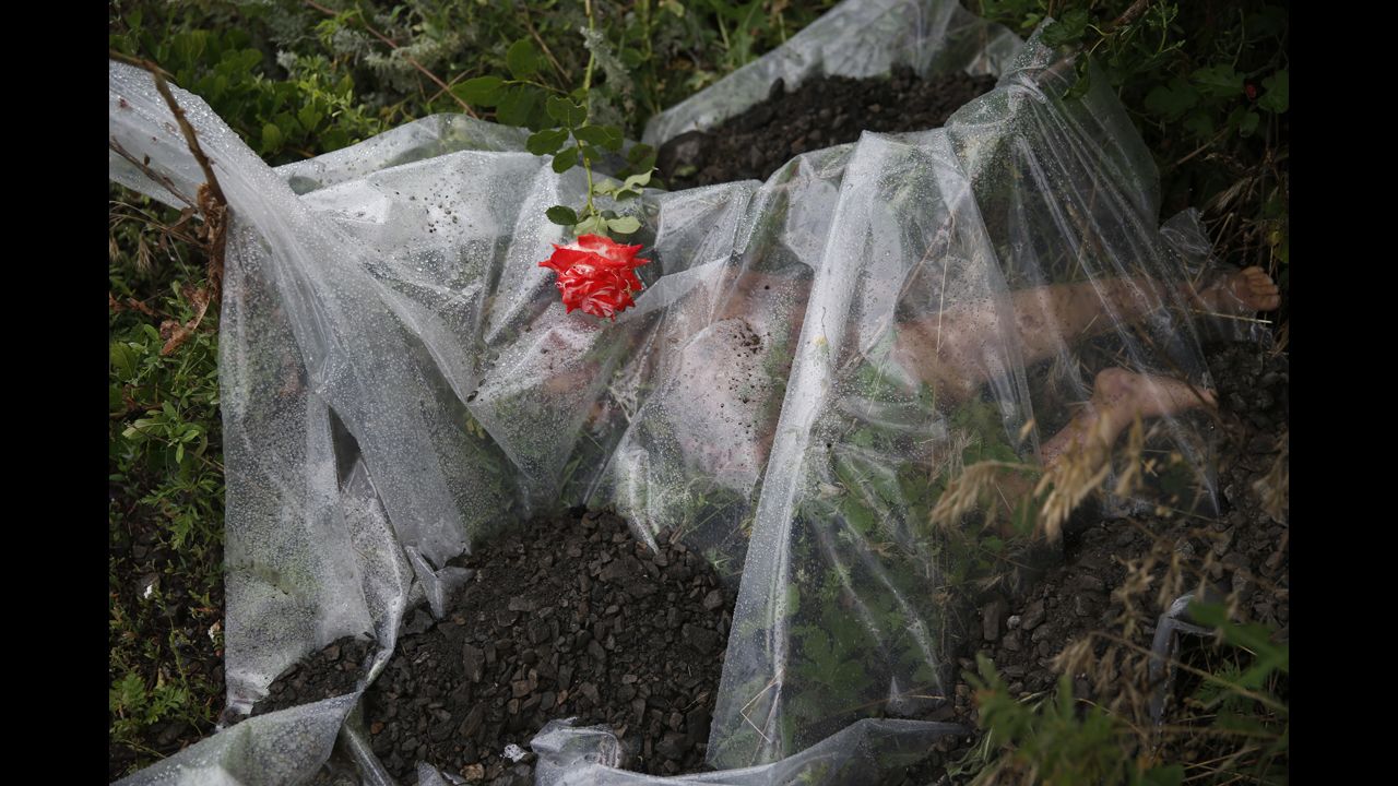 <strong>July 18:</strong> A rose lies on a plastic sheet covering a victim of <a href="http://www.cnn.com/2014/07/18/world/gallery/malaysia-airlines-reaction/index.html">Malaysia Airlines Flight 17,</a> which was shot down over war-torn eastern Ukraine. All 298 people aboard the flight were killed. Several Western nations and the Ukrainian government <a href="http://www.cnn.com/2014/11/16/world/europe/netherlands-ukraine-mh17-wreckage/index.html">have accused pro-Russian rebels</a> of shooting down the plane with a missile. Rebel leaders and the Russian government have disputed the claims.