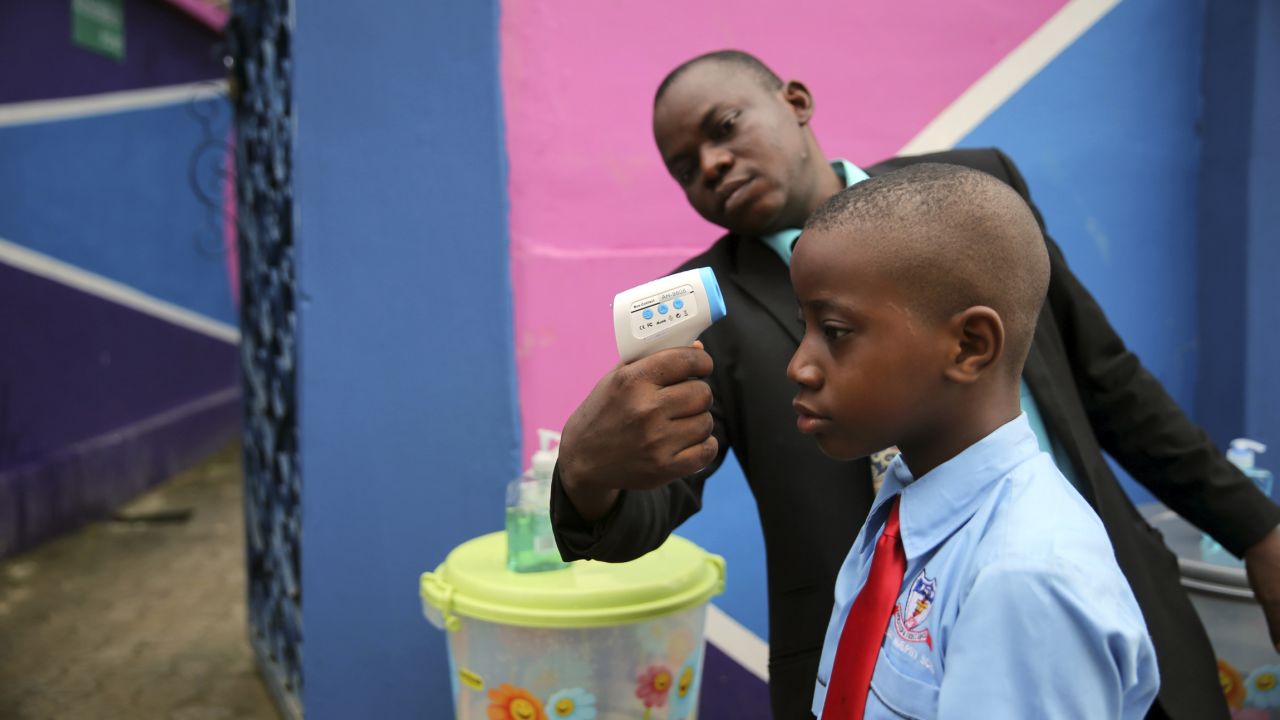 <strong>September 22:</strong> Amid the Ebola scare in West Africa, a school official in Lagos, Nigeria, takes a student's temperature with an infrared laser thermometer. Health officials say <a href="http://www.cnn.com/2014/04/04/world/gallery/ebola-in-west-africa/index.html">the Ebola outbreak in West Africa</a> is the deadliest ever. More than 5,600 people have died there, according to the World Health Organization.