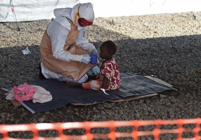 The Ebola outbreak has seen over 1,400 new cases in Sierra Leone in the last three weeks alone, making the country set to eclipse Liberia as the worst-effected country on the globe, according to the <a href="index.php?page=&url=http%3A%2F%2Fapps.who.int%2Fgho%2Fdata%2Fview.ebola-sitrep.ebola-summary-latest%3Flang%3Den" target="_blank" target="_blank">World Health Organisation. </a>Here, a health worker in protective gear gives a drink to a tiny patient at the Kenama Treatment Center.