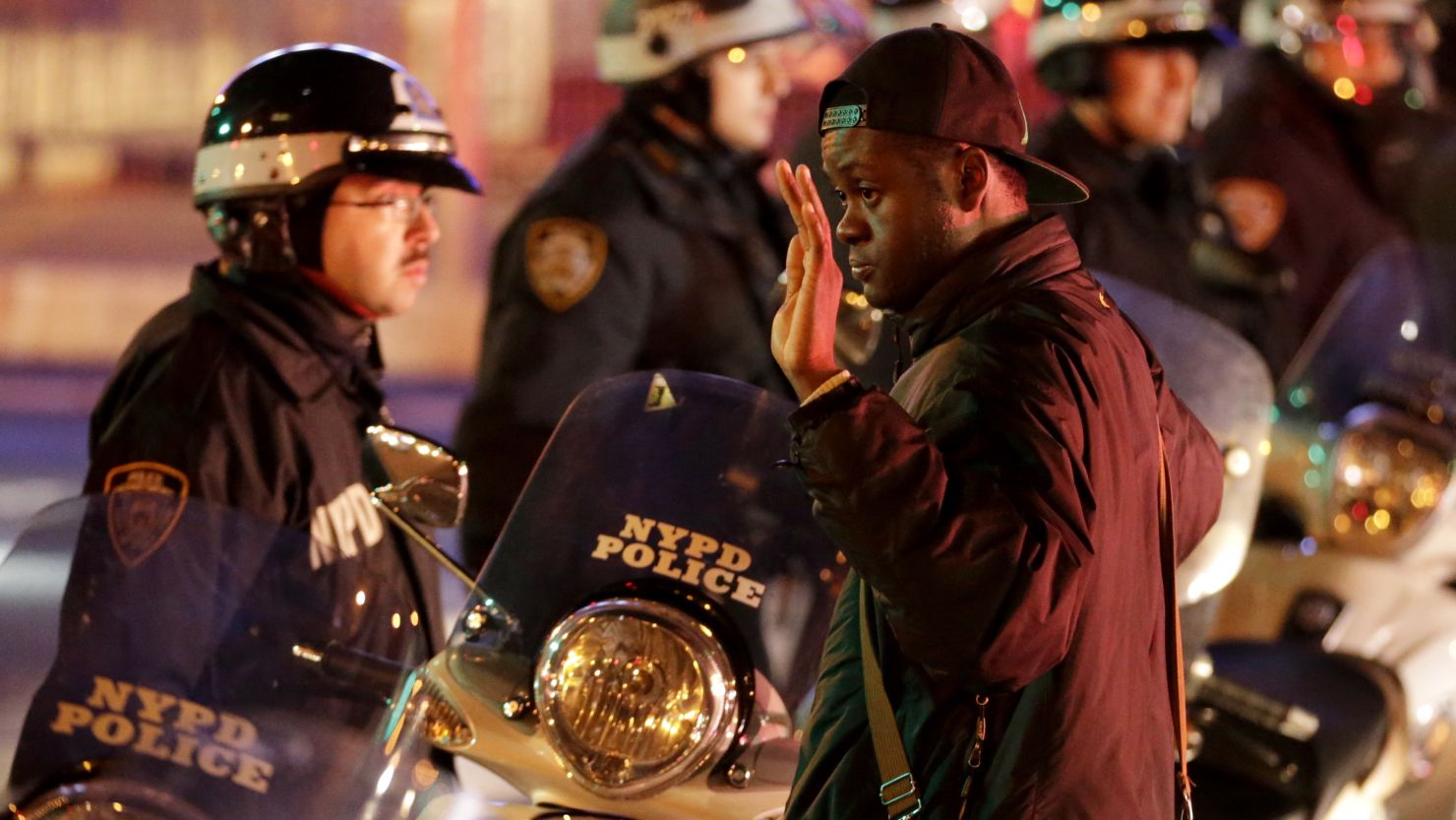 A man stands with his hands raised in front of a line of police officers during a protest after it was announced that the New York City police officer involved in the death of Eric Garner was not indicted, Wednesday, Dec. 3, 2014, in New York. A grand jury cleared the New York City police officer Wednesday in the videotaped chokehold death of Garner, an unarmed black man, who had been stopped on suspicion of selling loose, untaxed cigarettes, a lawyer for the victim's family said. (AP Photo/Julio Cortez)