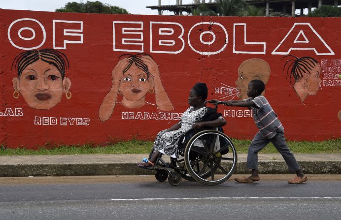 A boy in Monrovia pushes a woman in a wheelchair past a wall bearing information about Ebola in September. Some villages lost their entire working-age populations, leaving countless orphans behind in their place. One nonprofit that works with orphans believes that <a href="http://www.street-child.co.uk/ebola-orphan-report/" target="_blank" target="_blank">more than 12,000 children</a> have lost their primary caregiver. Schools were shut down for almost a year and <a href="http://www.savethechildren.org/site/c.8rKLIXMGIpI4E/b.9187887/k.9CB7/Helping_Children_Survive_the_Deadly_Ebola_Outbreak_in_Africa.htm?msource=weklpebo0814" target="_blank" target="_blank">only recently reopened. </a>
