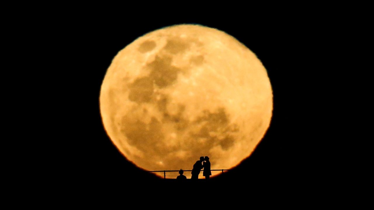 <strong>September 9:</strong> A couple kiss during a perigee moon, also known as a "supermoon," as it rises in the sky in Sydney. The phenomenon occurs when the moon becomes full on the same day as its perigee -- the point in the moon's orbit when it is closest to Earth.