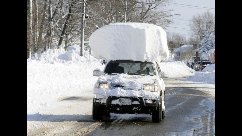<strong>November 19:</strong> A vehicle with a large chunk of snow on its roof drives along Route 20 after a massive snowfall in Lancaster, New York. <a href="http://www.cnn.com/2014/11/19/us/gallery/wintry-weather/index.html">A ferocious storm</a> dumped large piles of snow on parts of upstate New York, trapping residents in their homes and stranding motorists on roadways.