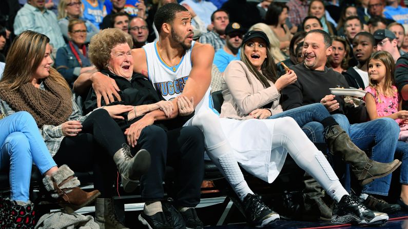 JaVale McGee #34 of the Denver Nuggets protects the fans as he ended up in the front row after saving the ball against the New Orleans Pelicans at Pepsi Center on November 21, 2014 in Denver, Colorado. The Nuggets defeated the Pelicans 117-97. 