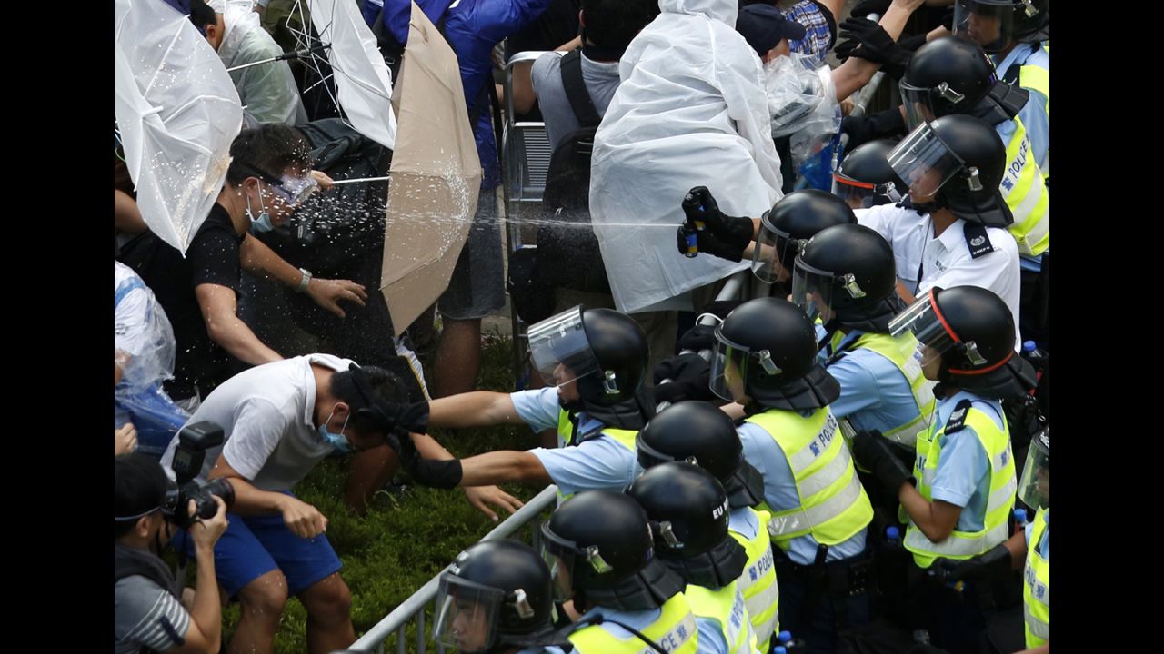 <strong>September 28:</strong> Riot police use pepper spray as they clash with pro-democracy protesters outside the government headquarters in Hong Kong. <a href="http://www.cnn.com/2014/09/22/asia/gallery/hong-kong-students-protest/index.html">Demonstrations began</a> in response to China's decision to allow only Beijing-vetted candidates to stand in the city's 2017 election for chief executive. Protesters say Beijing has gone back on its pledge to allow universal suffrage in Hong Kong, which was promised "a high degree of autonomy" when it was handed back to China by Britain in 1997. The umbrella has become the defining image of the protest movement, used to shield protesters from tear gas and the elements.
