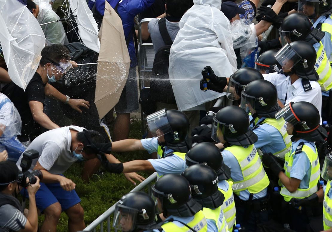 Riot police use pepper spray as they clash with protesters September 28, 2014. 