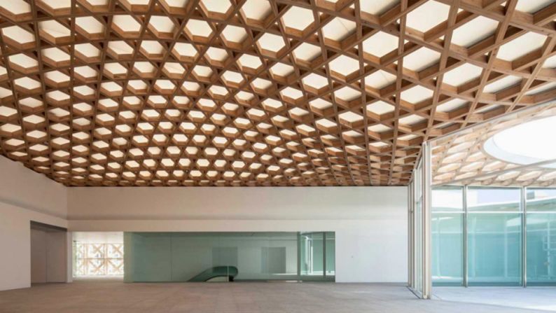 The 80-meter-long box is covered in a woven bamboo facade that continues on the interior.