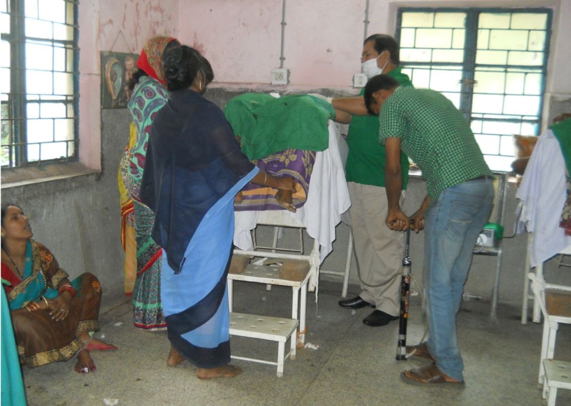 Medical staff use a bicycle pump to inflate a patient's abdomen during surgery.