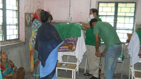 Medical staff use a bicycle pump to inflate a patient's abdomen during surgery.