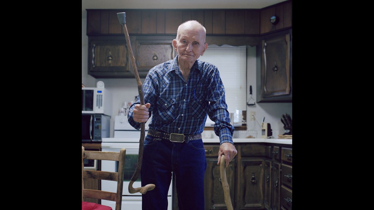 Local resident Bob Morgan holds up one of the many walking sticks he carved himself. Morgan, a World War II veteran and cowboy, was building barns and bending metal into his 80s, Hoste said. He passed away in August at the age of 89.