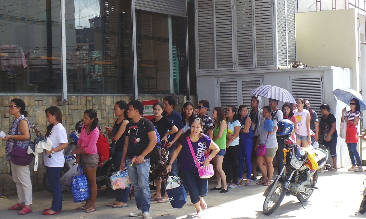 Typhoon Haiyan survivors, some of whom are still living in tents, queue up to buy groceries in Tacloban city, in central Philippines in anticipation of the incoming Typhoon Hagupit which is forecasted to hit the country this weekend.