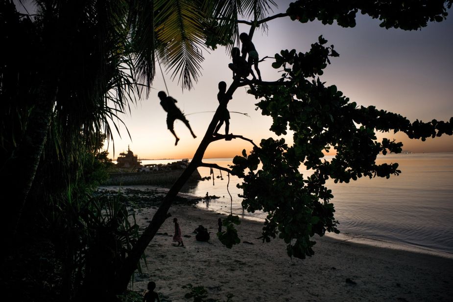 Children play on a swing. Kiribati's youth may be the last generation to live on these islands.